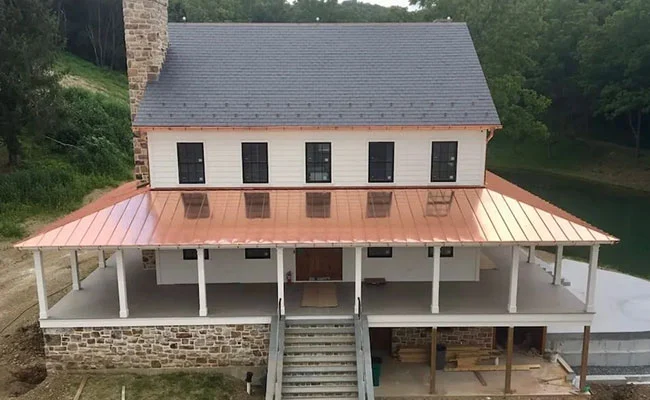 A recently renovated house with a standing seam copper porch roof